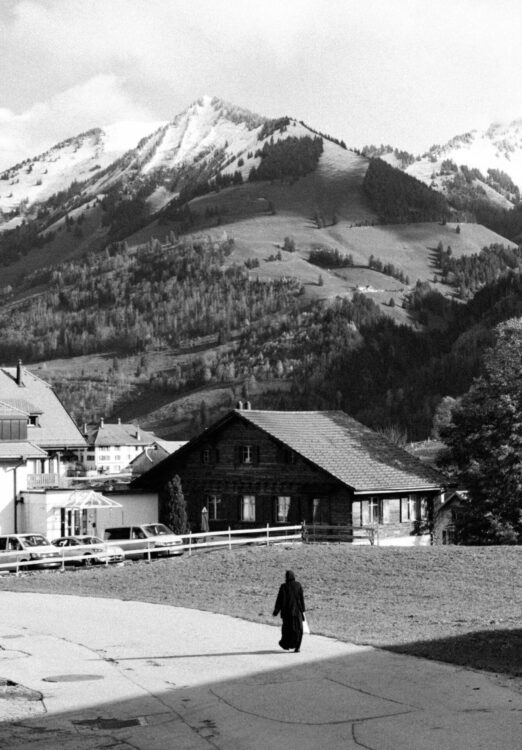 Femme religieuse dans une ruelle dans la vallée de L'Intyamon